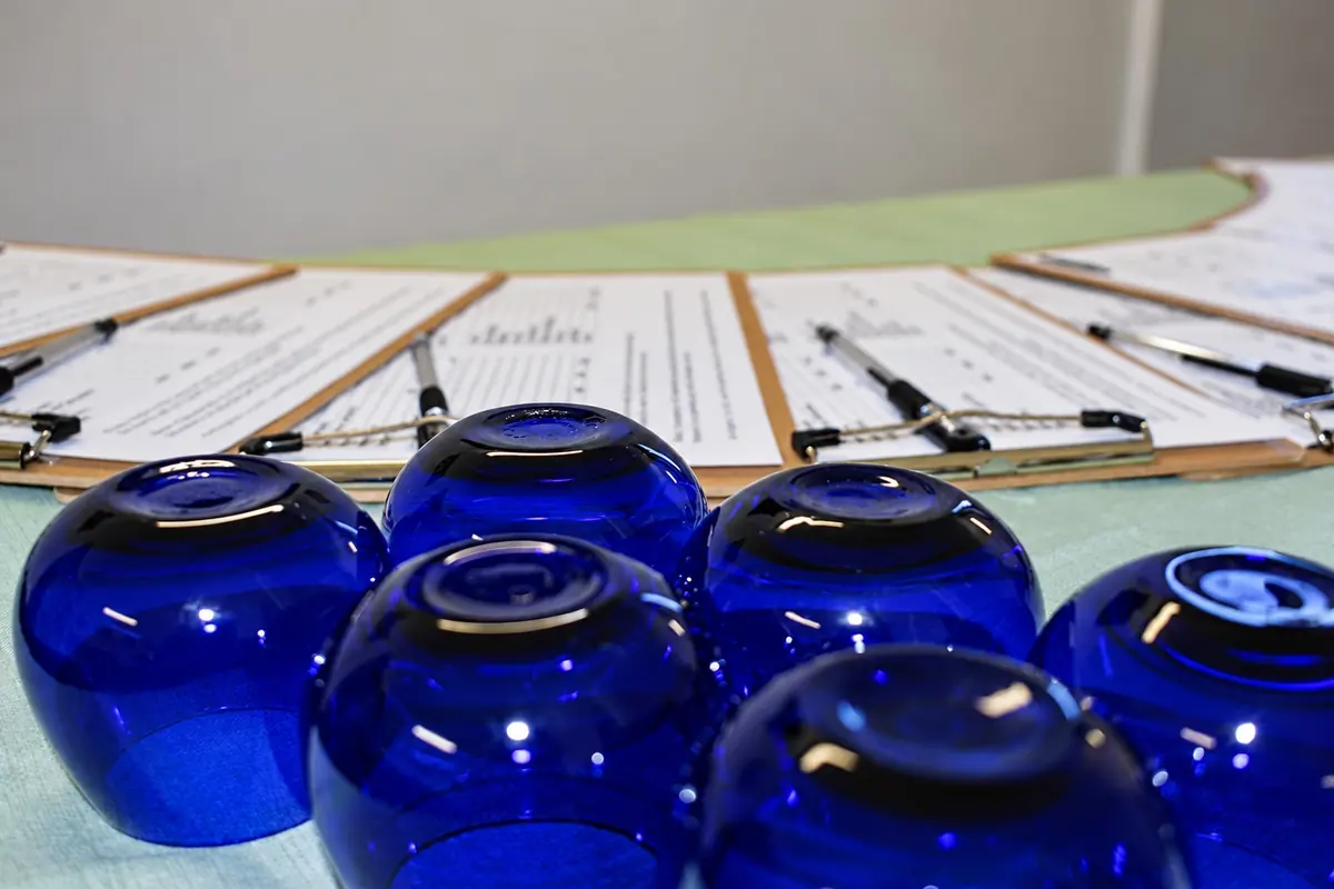 I bicchieri blu e le schede della degustazione sul tavolo
